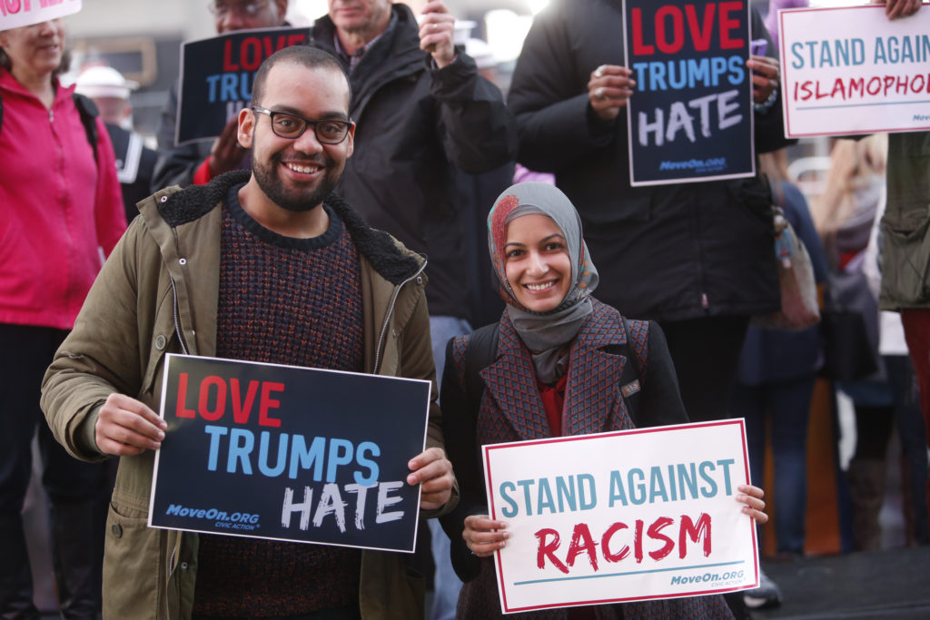"NEW YORK, NY - MARCH 16: Ben O'Keefe and Iram Ali of MoveOn.org Political Action stand outside the studios of "Good Morning America" to broadcast messages of love, dignity, and equality and stand up against the hate, racism, and incitement of violence that the group says has become a hallmark of Donald Trump's presidential campaign in New York City on Wednesday, March 16, 2016 in New York City. (Photo by Thos Robinson/Getty Images for MoveOn.org Political Action)"