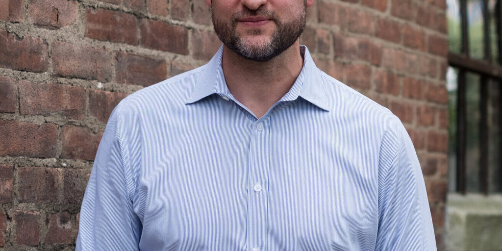 Pat Ryan in front of brick building