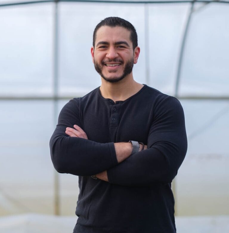 This is an image of Abdul El-Sayed, candidate for Michigan Senate. He is pictured in a black shirt in front of a bridge.