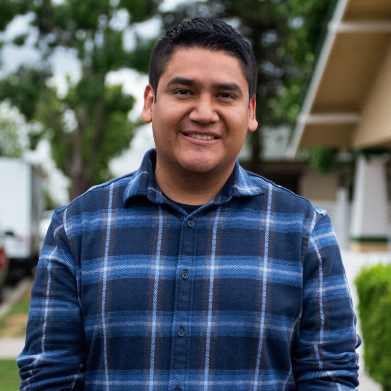 This is an image of Randy Villegas, candidate for California's 22nd Congressional District. He is pictured in a blue shirt in front of a house.
