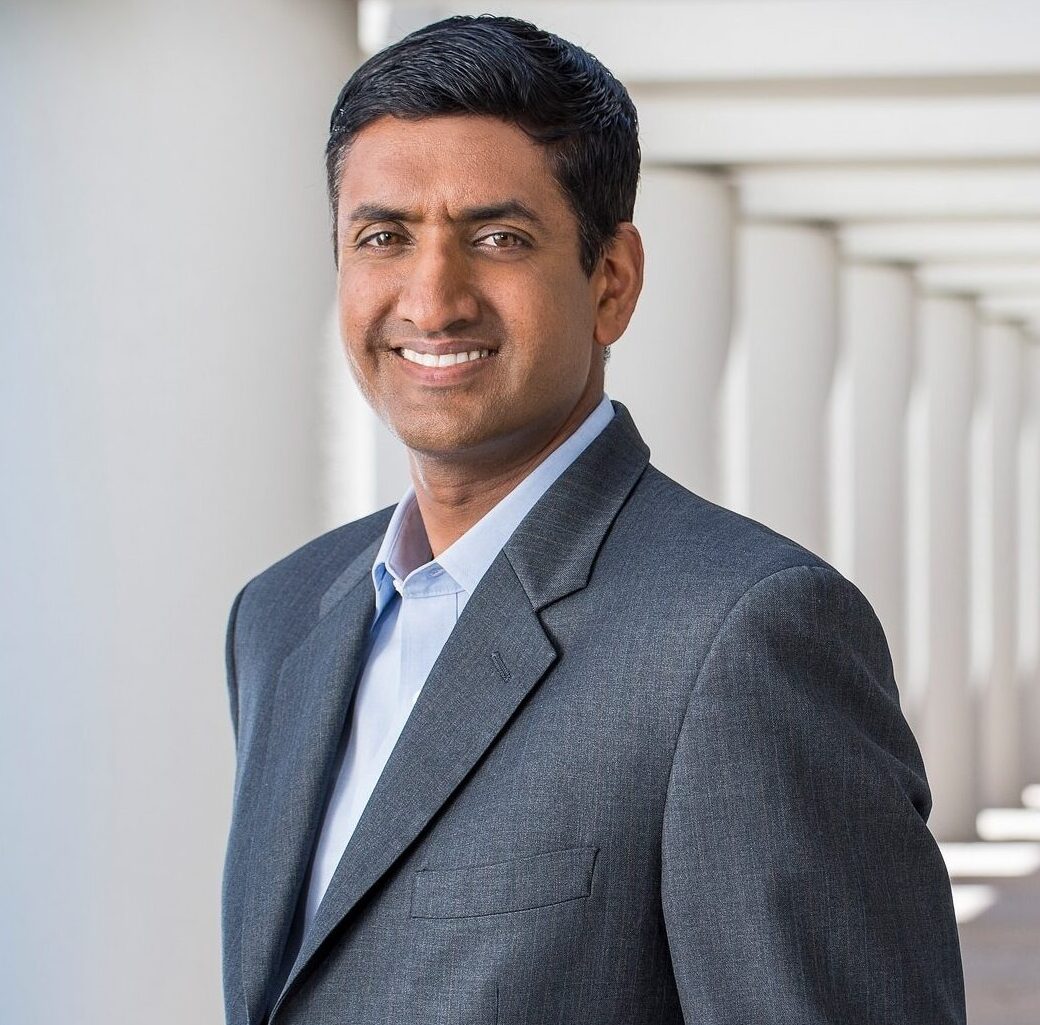 This is an image of Ro Khanna, candidate for California's 17th Congressional District. He is pictured in a gray suit standing in front of white pillars.